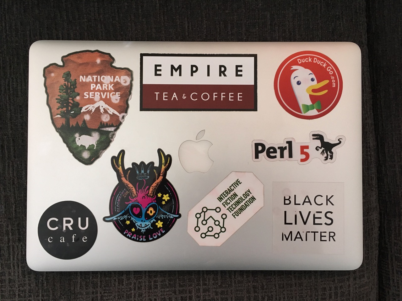 The lid of a silver MacBook Pro, covered with all the stickers described in this article.