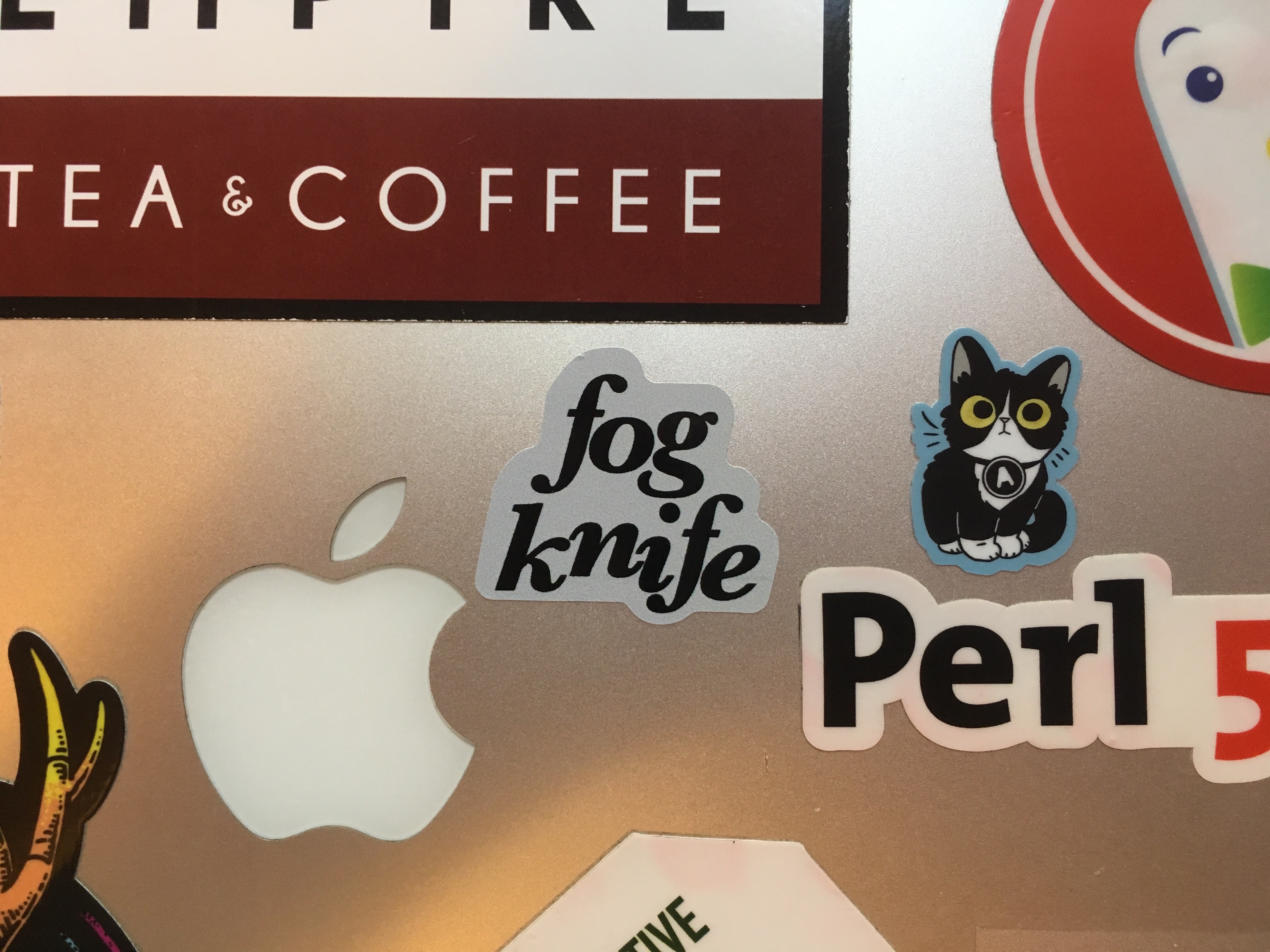 Photograph of a small sticker reading 'Fogknife', attached to a Mac laptop cover.