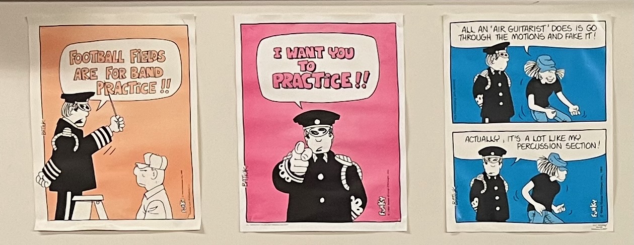 A close up of three posters: 'Football fields are for band practice!!', 'I want you to practice!!', 'All an air guitarrist does is go through the motions and fake it! Actually, it's a lot like my percussion section!'
