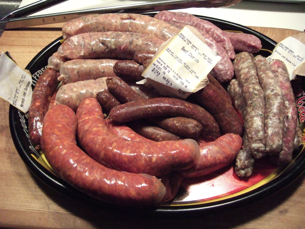 Photograph of a plate of uncooked sausages.