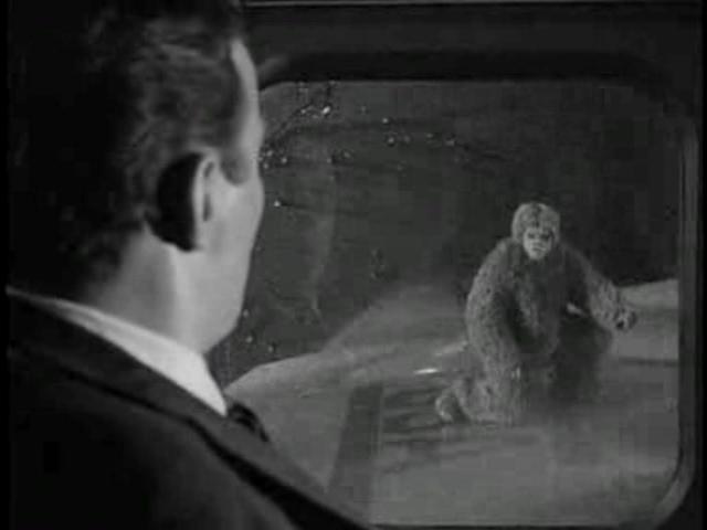 A young William Shanter looks out a window, through the rain, at an airplane wing. A hideous monster (actually a man in a sort of modified gorilla suit) is kneeling on the wing, looking back at him.